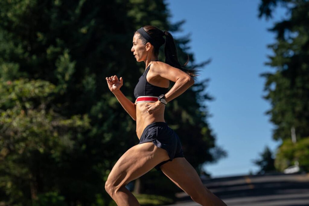 vista lateral de uma mulher correndo ao ar livre em alta velocidade