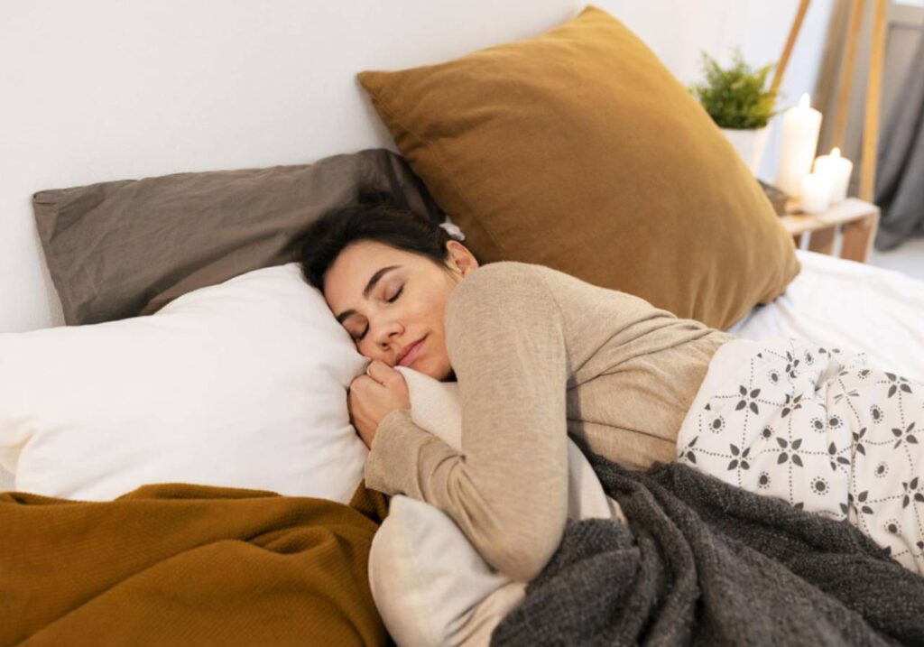 mulher dormindo na cama com alguns travesseiros ao seu redor
