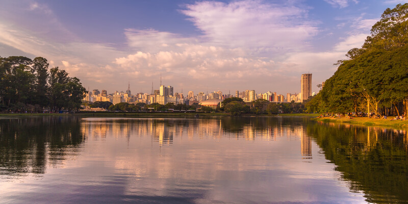 Pôr do sol sobre o lago e skyline de São Paulo